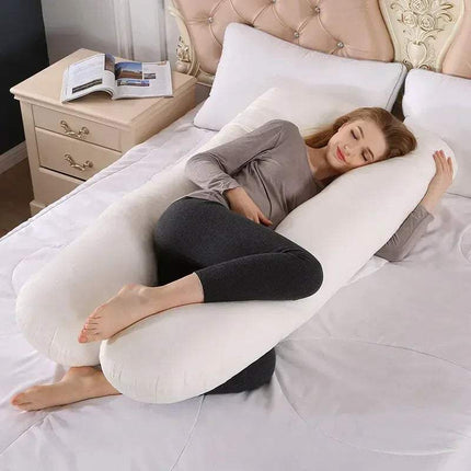Woman lying on a U-shaped 130x70cm Pregnancy Pillow in a bedroom setting.