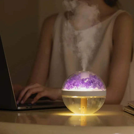 270ML Flower Air Humidifier Person using a laptop with a glowing spherical device emitting mist on a table.