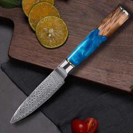 3.5 Inch Paring Knife VG10 Damascus Steel  with a blue handle on a wooden cutting board with sliced citrus fruits
