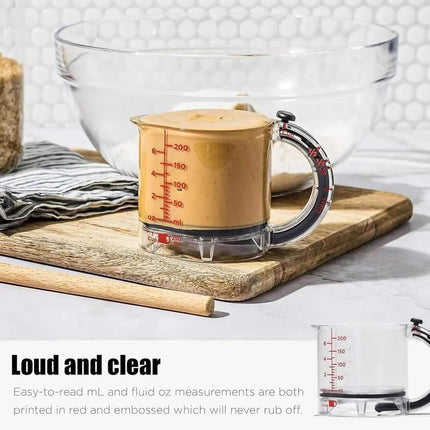 4-in-1 Adjustable Measuring Cup Measurement cup with clear handle on a wooden cutting board with text 'Loud and clear'.