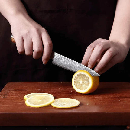 5 Inch Small Kitchen Knife. Person slicing a lemon on a wooden cutting board with a chef's knife.