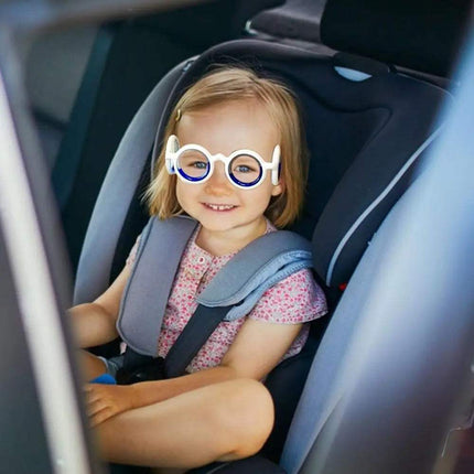 Child wearing Glasses Against Motion Sickness in a car seat, happy and relaxed during travel.