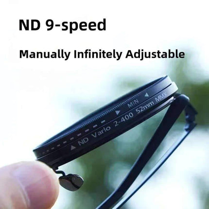 Adjustable Dimming Sunglasses. ND 9-speed manually infinitely adjustable filter held by a hand with blurred green background