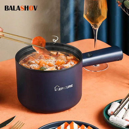 Blue portable All-In-One Mini Electric Cooker for Quick & Easy Meals with food being served, surrounded by dining utensils and a glass of champagne on a table.