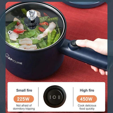 Black All-In-One Mini Electric Cooker with food being cooked, showing power settings on a red surface.