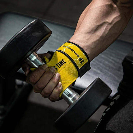 Hand wearing a yellow Weightlifting Grip Pads holding a dumbbell in a gym setting
