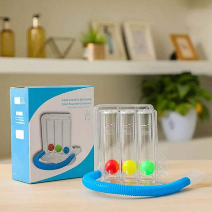 breathing balls exerciser Respiratory exercise device with colorful balls and packaging on a table.