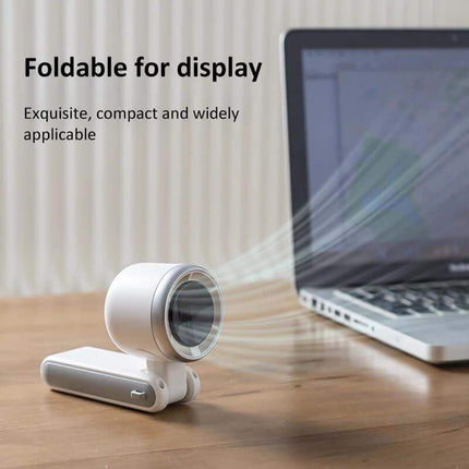 Handheld Turbo Fan. Foldable display device on a desk with a laptop in the background