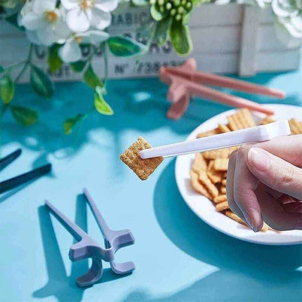 Snack Grabbers. Hand holding a cracker with a white stick over a bowl of crackers on a blue surface with flowers in the background.