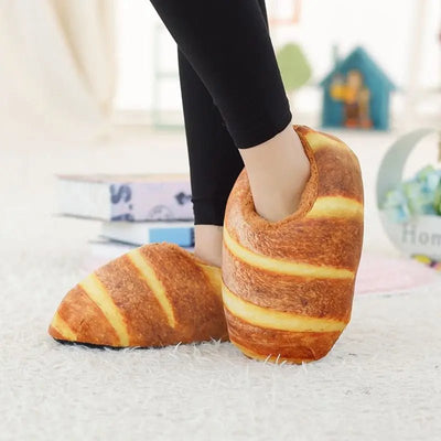 Bread Slippers. Croissant-shaped slippers worn by a person indoors.