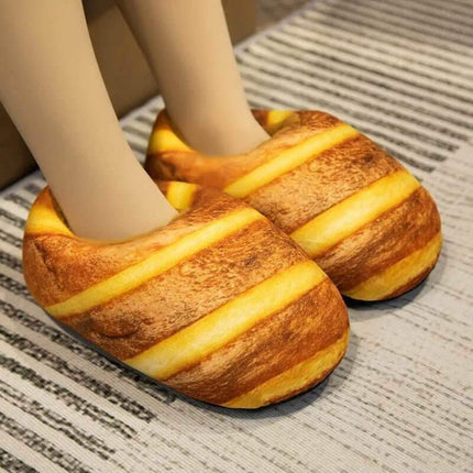 Bread Slippers shaped like a loaf of bread with striped design worn by a person on a textured floor.