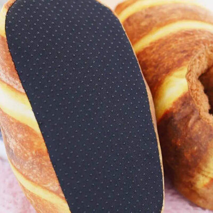 Bread Slippers. Black shoe insole with textured surface on a bundt cake background