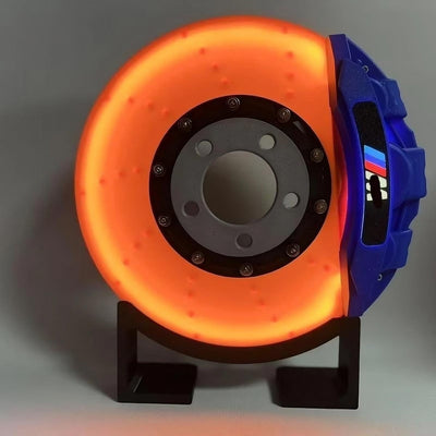 Orange and blue mechanical component on a stand against a gray background