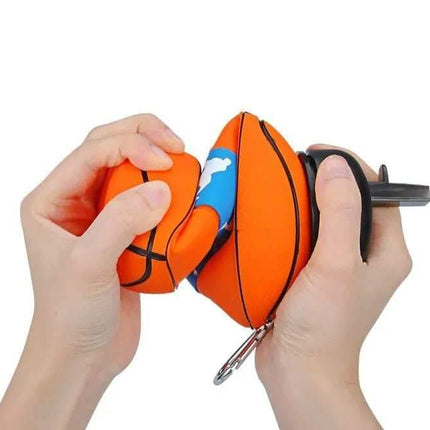 Foldable Sports Ball Bottle. Hands holding a keychain shaped like a basketball with a blue and white design on a white background