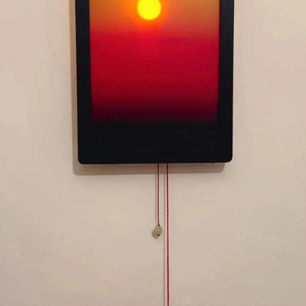 Kinetic Sunrise Wall Light adjustable sunset glow lamp illuminating a room, with hand pulling a cord.