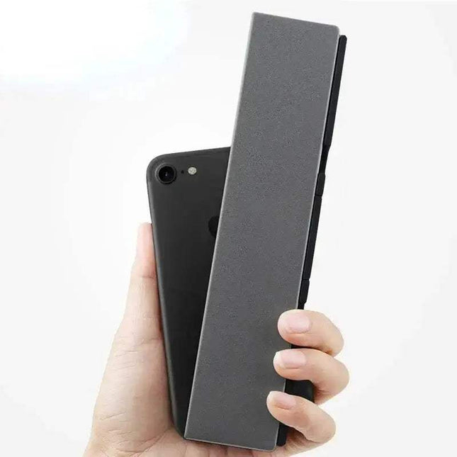 Hand holding a smartphone with Mini Foldable Bluetooth Keyboard for Travel & Work