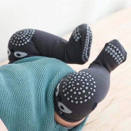Baby Knee Non-Slip Floor Socks Baby's legs wearing dark gray socks with patterned toes on a light background