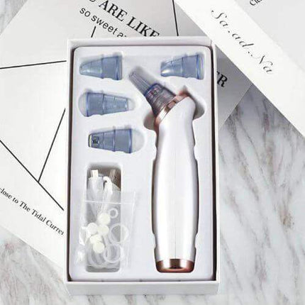 Blackhead Removal Suction Tool  with attachments in a box on a marble surface