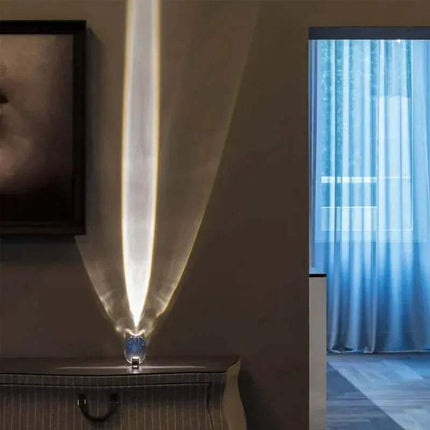 Crystal Atmosphere Lamp Elegant Ambient Lighting Modern lamp with a feather design casting light on a wall next to a window with blue curtains. - Astoria Lifestyle