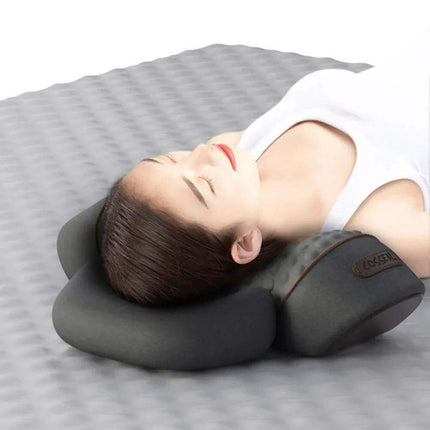 Person lying on a gray surface with a Electric Neck Massage Pillow, wearing a white tank top.