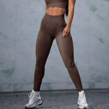 Person wearing brown Fitness Sports Leggings Women Seamless Gym Running Yoga Sportswear and crop top against a gray background