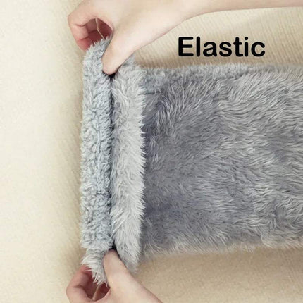 Gray Fuzzy Leg Warmer Stockings with elastic edge being pulled apart on a beige background