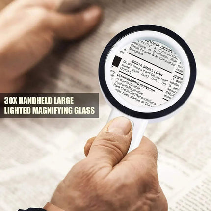 Handheld 30x Magnifying Glass held by a person over printed text on paper.