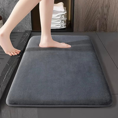 Memory Foam Bathroom Mat. Person stepping onto a gray bath mat in a bathroom setting