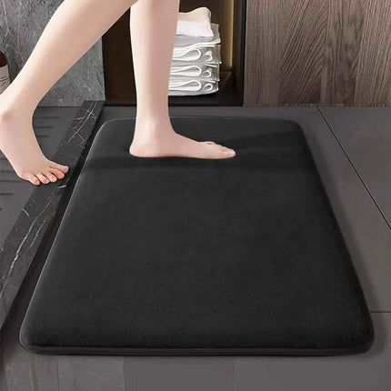 Memory Foam Bathroom Mat. Person stepping onto a black bath mat in a bathroom setting.