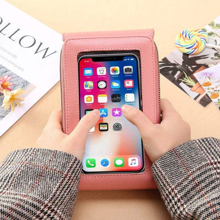 Person using a pink Small Bag for Females with Transparent Touch Screen Area with a smartphone inside, on a light surface.