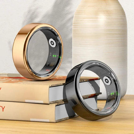 Two Smart Ring with digital displays on a wooden surface with books and a vase in the background. Astoria Lifestyle