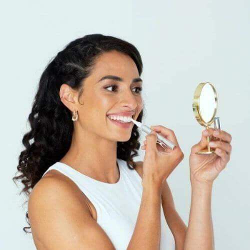 Woman using  a Teeth Whitening Pen for Fast & Effective Smile Brightening