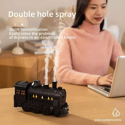 Train Air Humidifier emitting steam and a woman using a laptop  on a wooden table.