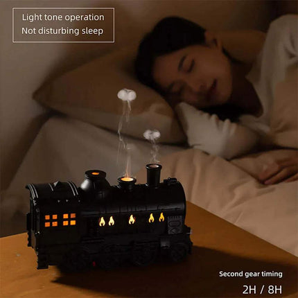 Train Air Humidifier. Woman sleeping in bed with a black train-shaped device on a wooden table next to her.