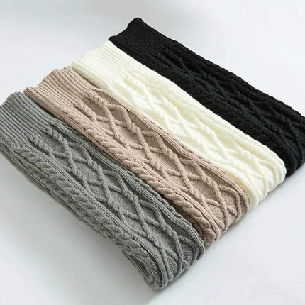 Stack of Winter Wool Over Knee Socks in gray, beige, white, and black on a light background