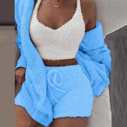 Person wearing a Womens Comfortable Knit Pajama Set white top and blue shorts with a matching blue jacket.