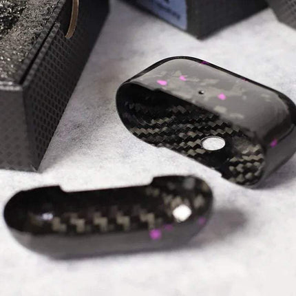 Close-up of a black Carbon Fiber Case for AirPods Pro on a gray surface.