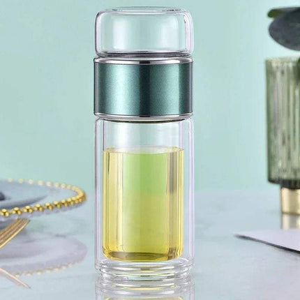 Tea Infuser Bottle with green liquid on a light blue background