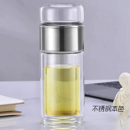 Tea Infuser Bottle with metal lid on a desk with a laptop and books in the background