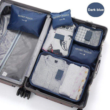 Open suitcase with blue 6Pcs Travel Clothes Storage Bags labeled 'Secret Pouch' on a white background