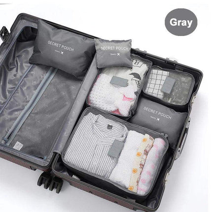 Open suitcase with gray 6Pcs Travel Clothes Storage Bags labeled 'Secret Pouch' on a white background