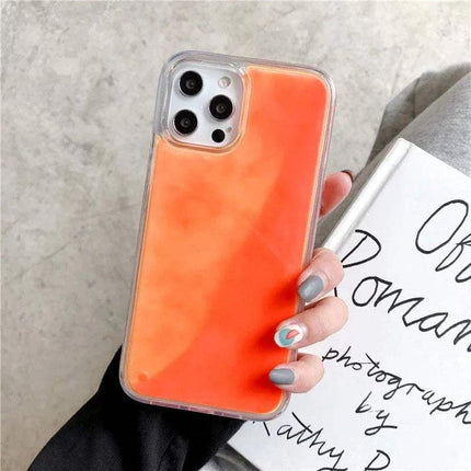 Hand holding a phone with an orange  Luminous Quicksand Phone Case on a concrete surface - Astoria Lifestyle