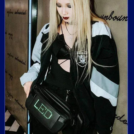 Person wearing a black and white jacket showcasing a Sling Bag with LED Display Bluetooth Programmable LED Fanny Pack against a decorative wall.