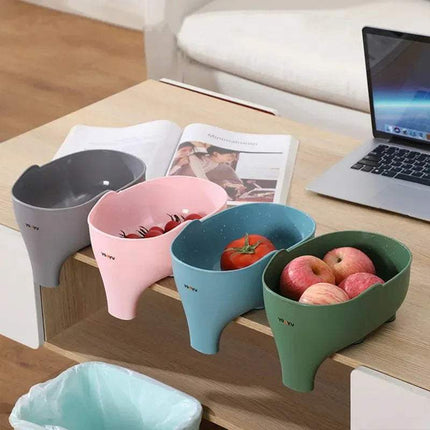 Colorful 2x Elephant Drain Baskets Cute & Functional Kitchen Sink Strainers on a wooden table with a laptop and magazine in the background.