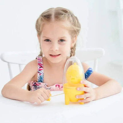 Young girl holding a yellow Egg Yolk Shaker Mixer Spinner Perfectly Blend Eggs in Seconds with a clear top, sitting on a white chair against a white background.