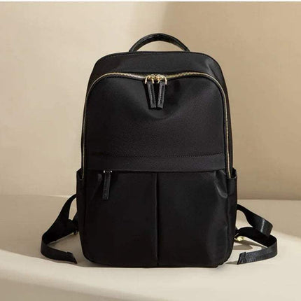 Black CFUN YA Luxury Backpack for Women with gold zipper on a beige background