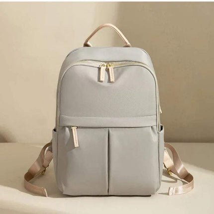 Light Gray CFUN YA Luxury Backpack for Women with gold zippers on a beige background