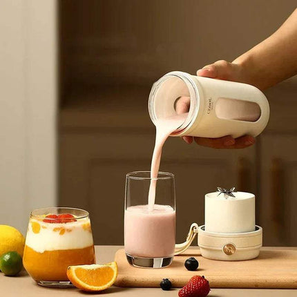 10 Blades Electric Portable Blender. Person pouring a creamy liquid from a container into a glass on a wooden surface with fruits and a candle.