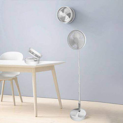 Folding Telescopic Floor Fan on a light wooden floor with a table and chairs in the background.