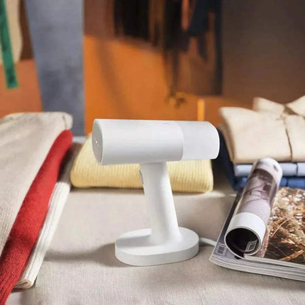 Handheld Garment Steamer on a table with a magazine in the background